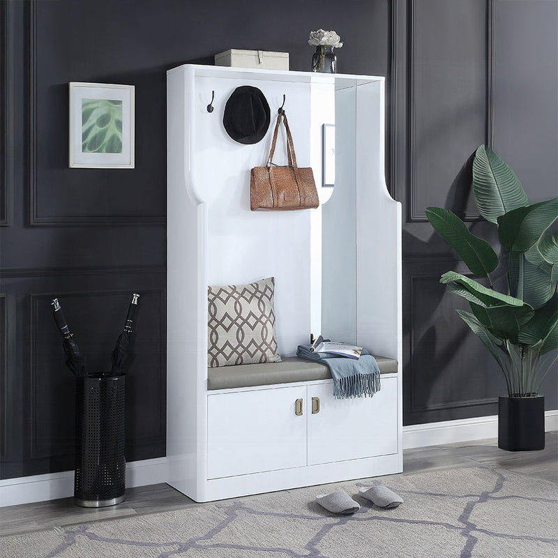 Modern white hall tree with cushioned bench, hooks holding a hat and handbag, storage cabinets below, and decorative accents in a stylish entryway.