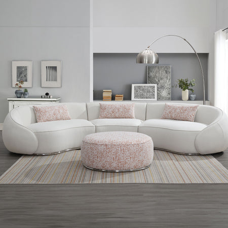 Modern living room with a white sectional sofa, patterned ottoman, and decorative elements.